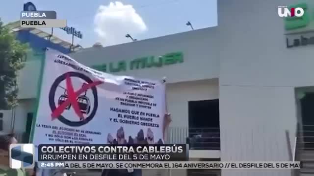 Poblanos protestan en contra del cablebús en Puebla durante el Desfile Cívico Militar del 5 de Mayo; con pancartas, consignas y volantes demostraron su RECHAZO al proyecto de Alejandro Armenta.