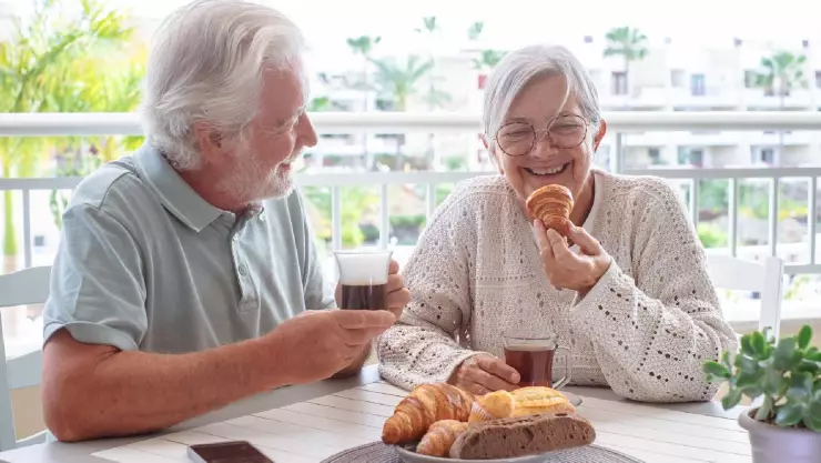 una pareja adulta desayuna feliz 