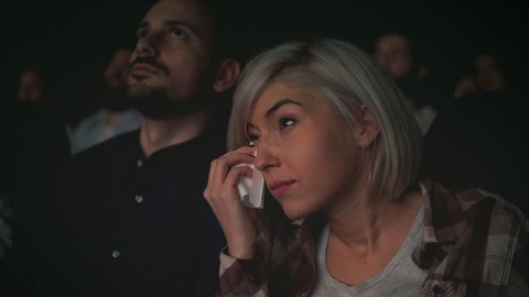 Mujer llorando por una película en el cine