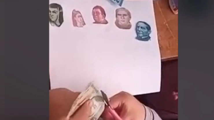 Niña recorta billetes para ilustrar su tarea
