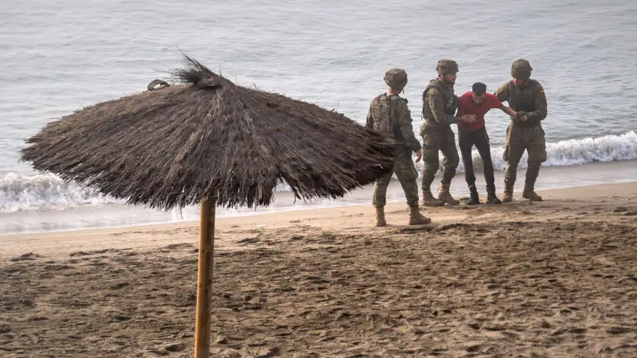 Soldados españoles ayudan a un migrante que llegó a nado a Ceuta.jpg