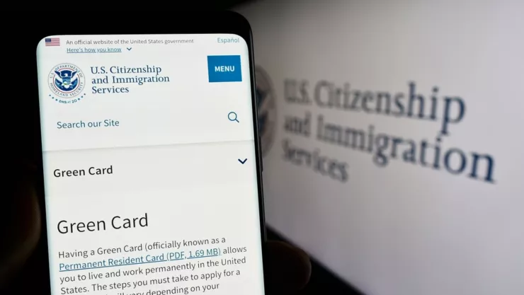 Se muestra la página web del USCIS en un teléfono móvil.