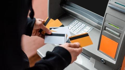 Una persona con muchas tarjetas en un cajero autom&aacute;tico.