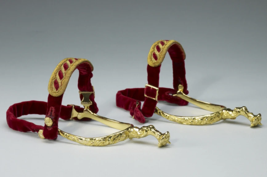 Las espuelas están hechas de oro, cuero y terciopelo. Simbolizan la caballería.