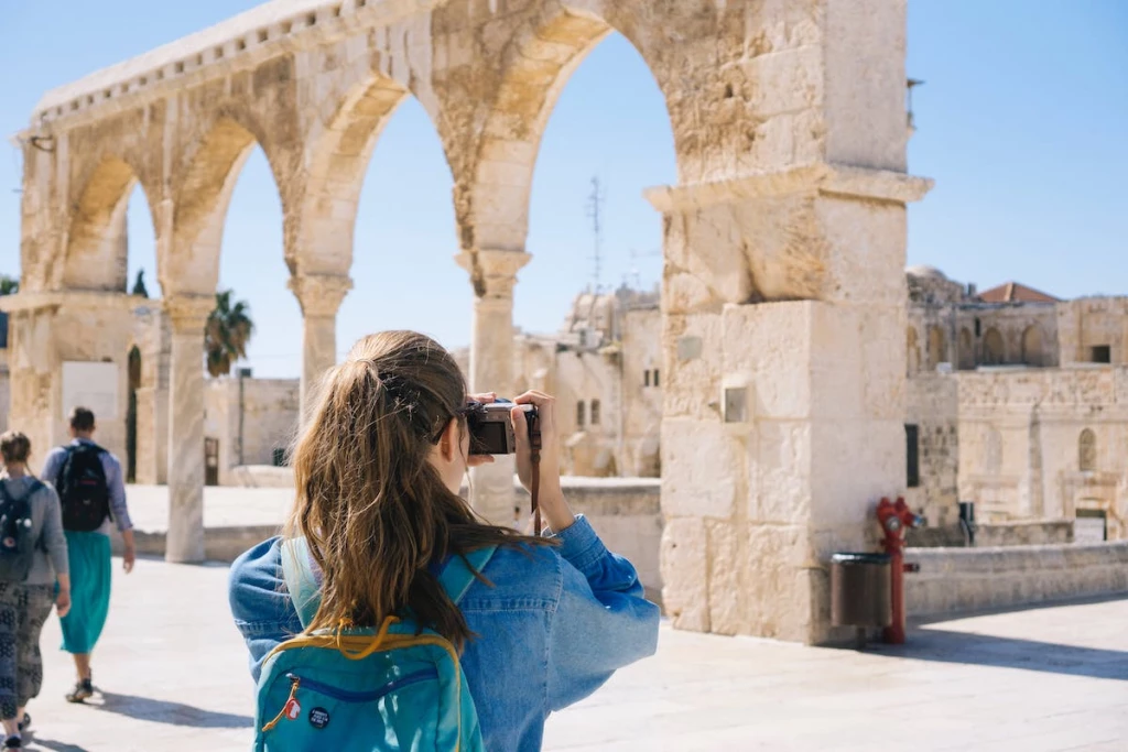 mujer tomando fotos de ruinas