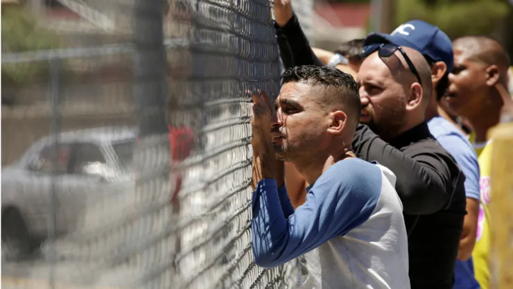 Hombres esperando a familiares mientras un grupo de migrantes llega a las instalaciones del Instituto Nacional de Migración de México tras ser deportados. Imagen, Reuters.