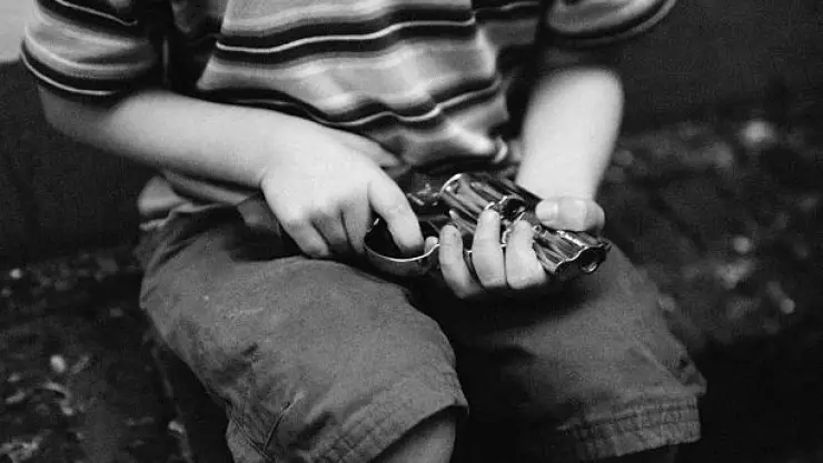 niño con arma de fuego