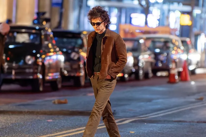 Los trajes no solo sirven para situar al espectador en una época específica, sino que también cuentan una historia dentro de la historia misma, ayudando a definir a los personajes, como el propio Bob Dylan, quien se encuentra en el centro de la película. El vestuario subraya la tensión y la emoción del entorno musical, haciendo de la moda un lenguaje visual que complementa la narrativa.
Crédito: Searchlight Pictures