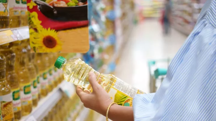 Mujer en supermercado comprando aceite