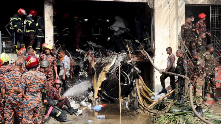 Bomberos y soldados trabajan junto a los restos de un avión de entrenamiento de la fuerza aérea después de que se estrellara en el campus de Milestone College, en Dhaka, Bangladesh , el 21 de julio de 2025