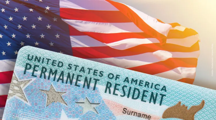 Una Green Card sobre una bandera estadounidense.