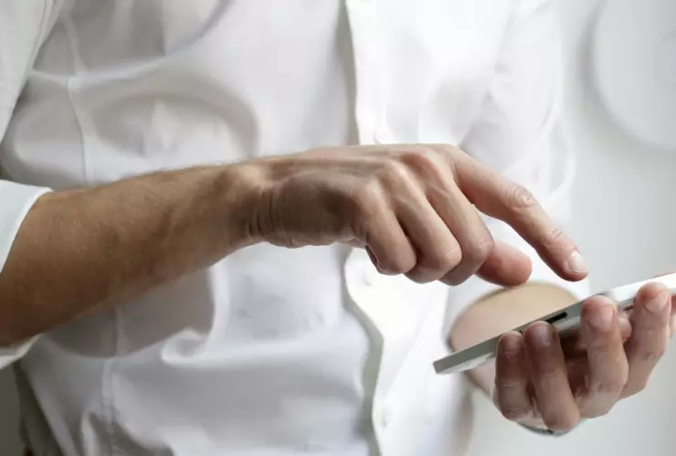 Persona sosteniendo un teléfono celular.