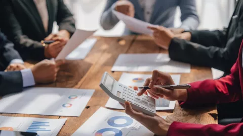 Unas personas hacen cálculos en un negocio.