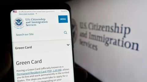 Se muestra la página web del USCIS en un teléfono móvil.