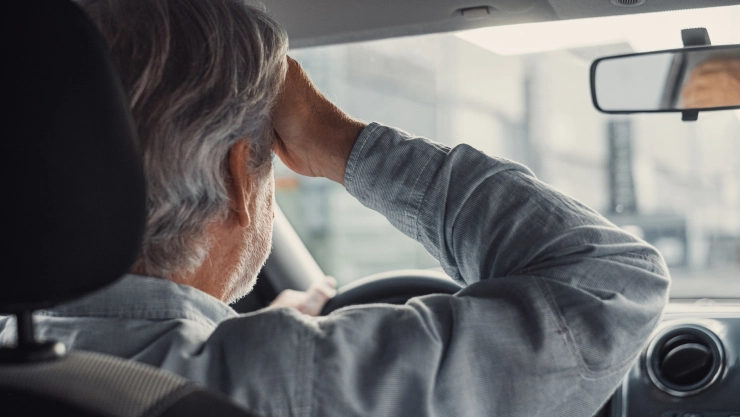 Una persona mayor conduce un auto