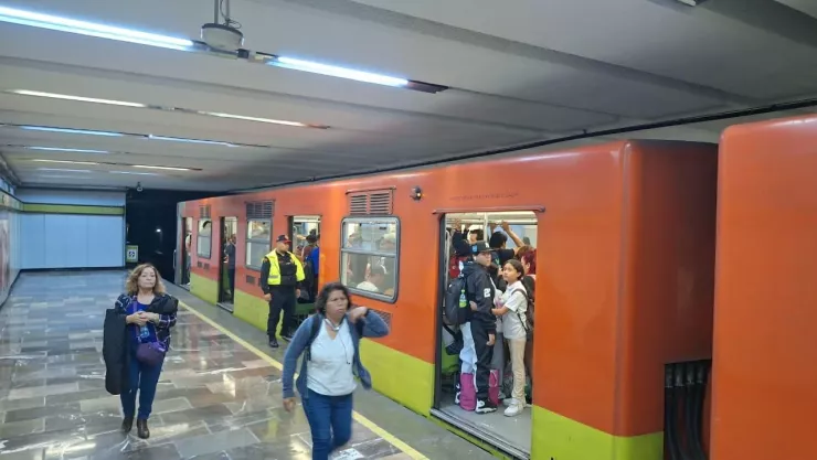 Personas caminando en el metro CDMX por retraso de trenes.