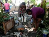 Mujeres llenan un cubo con agua después de que el río La Digue se desbordara debido a las intensas lluvias provocadas por el huracán Melissa, causando graves inundaciones en Petit Goave, Haití , el 4 de noviembre de 2025.