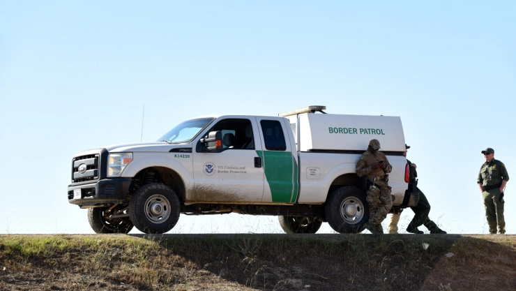 La patrulla fronteriza con tres agentes al rededor del vehículo