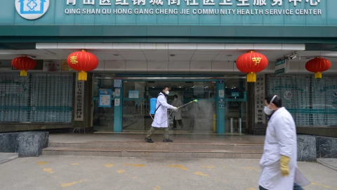 Doctor disinfects the entrance of a community health service center in Wuhan
