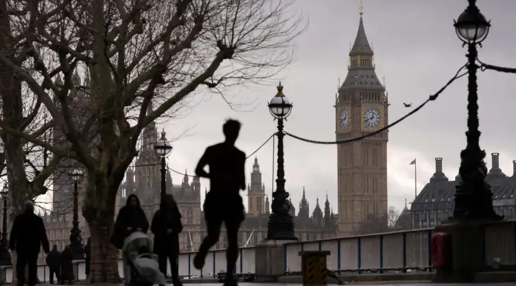 Gente camina a la orilla del río Támesis junto a la torre del Big Ben.