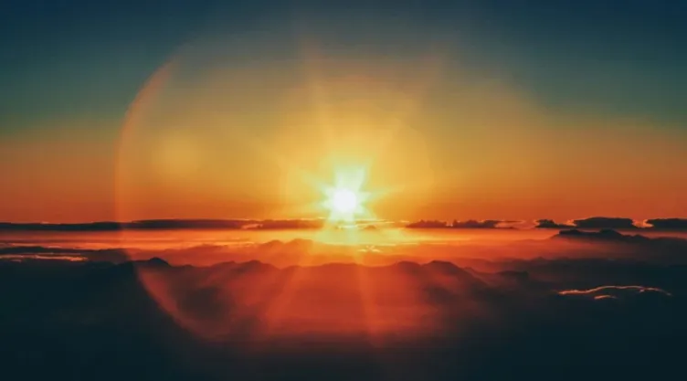 La puesta de sol sobresaliendo sobre el horizonte.