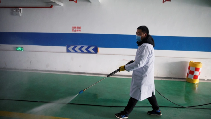 A worker sprays the underground parking of an office building with disinfectant in Changsha