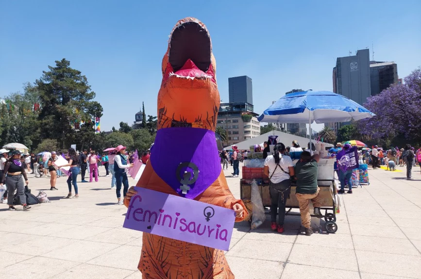 Mujer llega vestida de dinosaurio para la Marcha 8M.