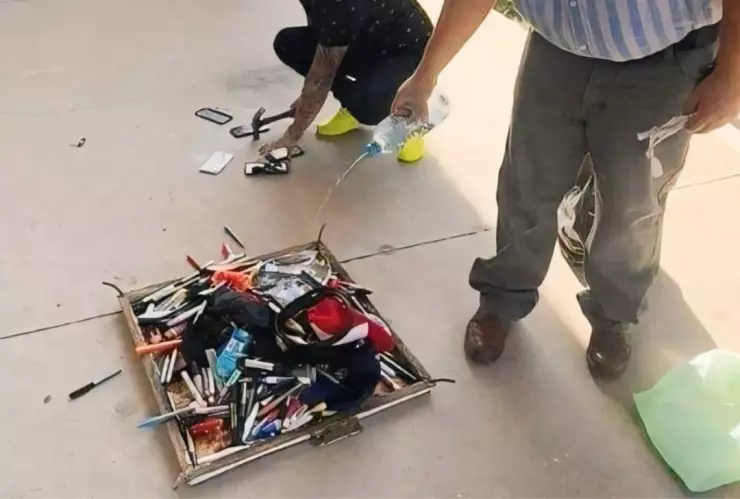 Maestros destruyen a martillazos celulares de sus alumnos y luego los queman