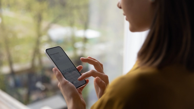 Una mujer envía un mensaje con el celular