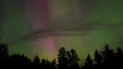 Las auroras boreales comienzan a iluminar el cielo en un espectáculo celestial.