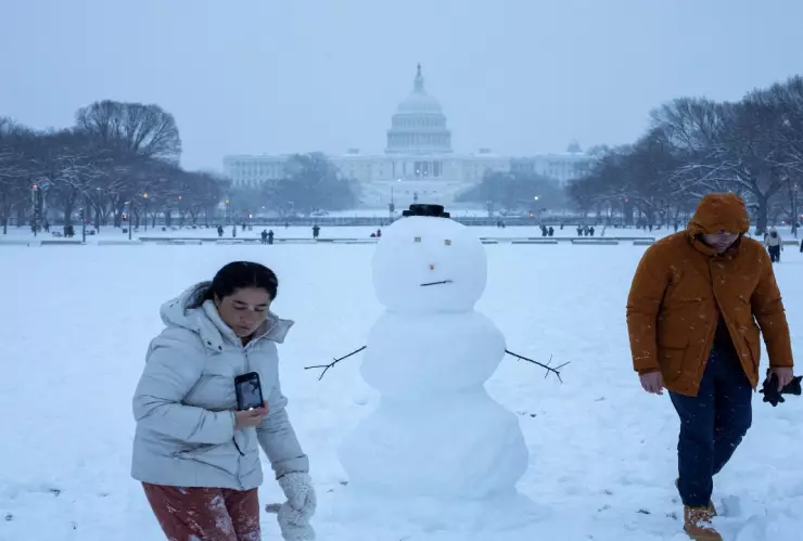 Vehículos cubiertos de nieve en una carretera durante la tormenta invernal Blair en Estados Unidos.