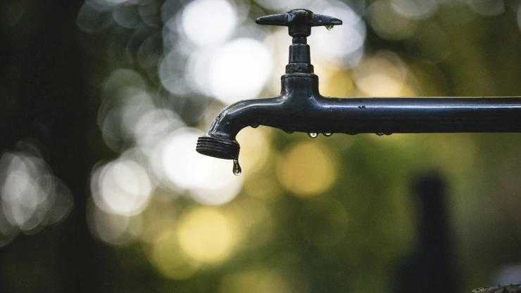Llave de agua con gotas cayendo de ella.