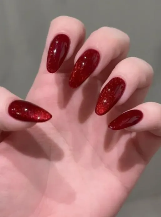uñas en rojo ojo de gato con glitter