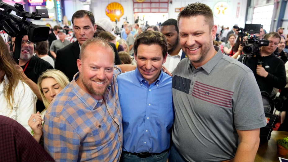 Ron DeSantis (centro) posa con partidarios.