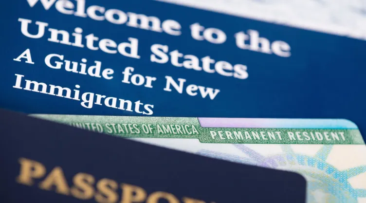 Fotografía de una Green Card y un pasaporte estadounidense.