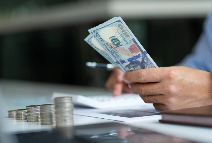 Una persona hace cálculos con dinero en dólares.