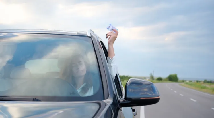 Una mujer enseña su licencia de conducir.