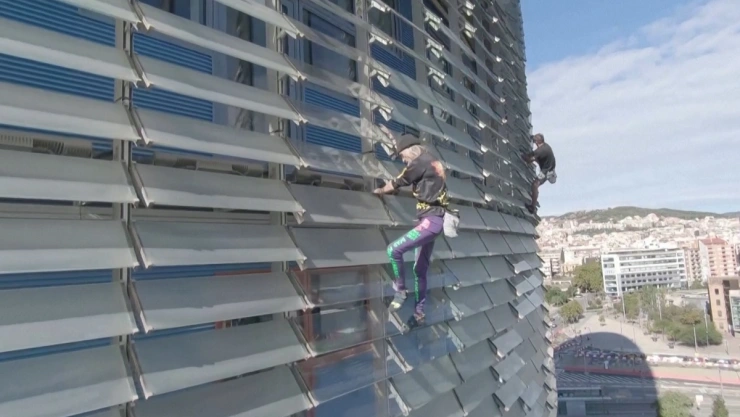 En Barcelona el Spiderman francés escala por primera vez un rascacielos junto a su hijo.
