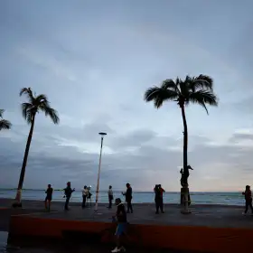Personas frente a una playa en Puerto Vallarta tras el paso del huracán Simón.