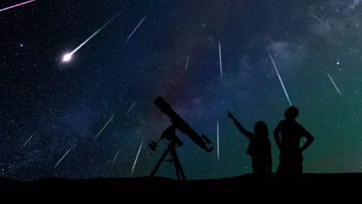 un padre y su hija disfrutan de una noche estrellada junto a su telescopio