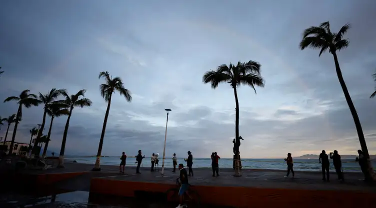 Personas frente a una playa en Puerto Vallarta tras el paso del huracán Simón.