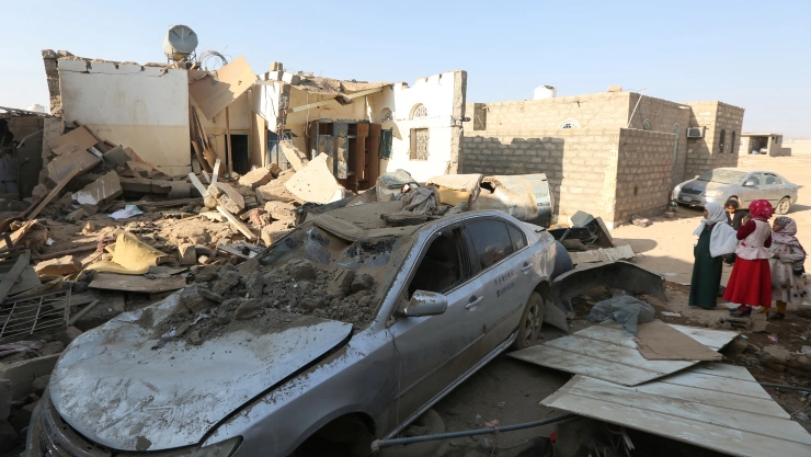 Girls stand at the site of a Houthi ballistic missile attack over the populated district of Rawda in Marib