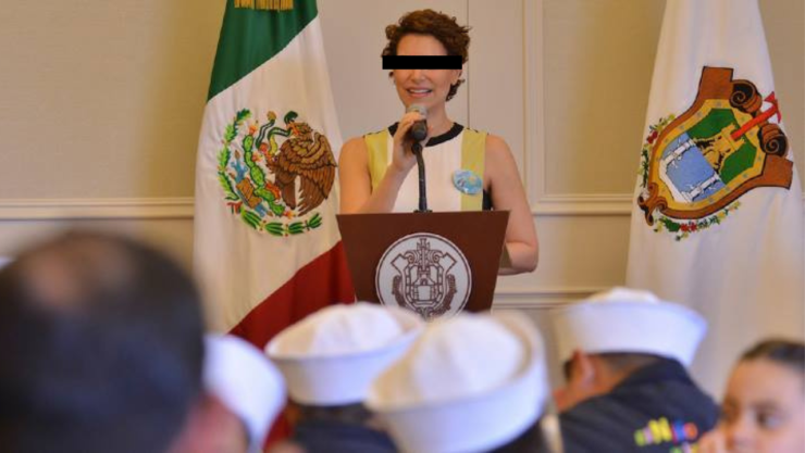 Karime Macías durante un acto público en Veracruz, frente a banderas oficiales, mientras sostiene un micrófono.