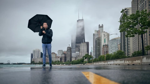 Hombre con paraguas camina por Chicago, Illinois, en medio de la lluvia