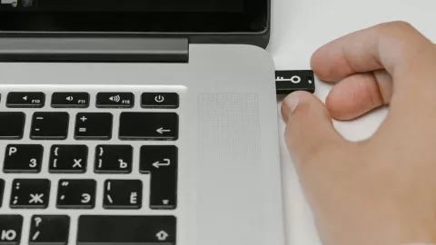 Una persona conectado una usb en su computadora MacBook Pro