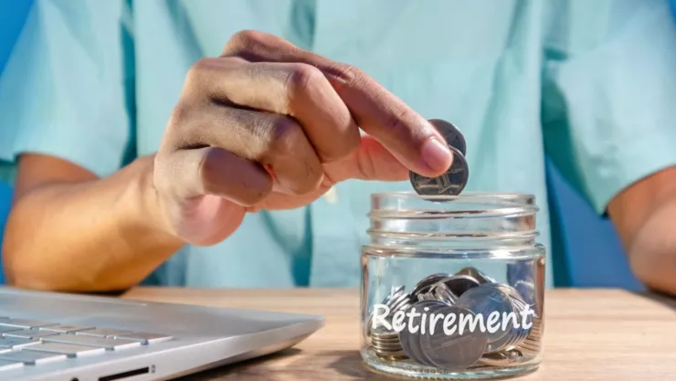 Un hombre pone monedas dentro de un frasco.