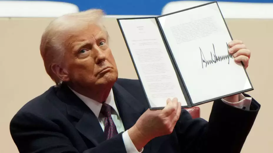 Donald Trump sostiene una orden ejecutiva firmada.