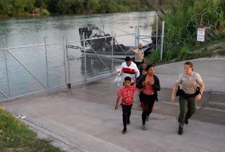 Una familia de extranjeros cruza la frontera entre México y Estados Unidos.