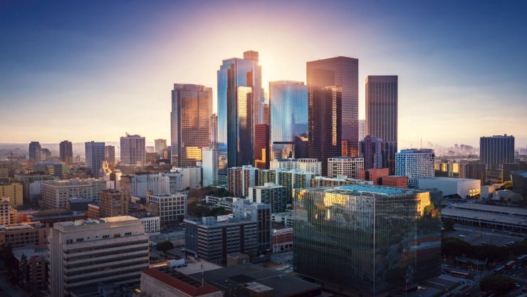 Un atardecer en la ciudad de Los Ángeles, estado de California, con el sol escondiéndose detrás de los grandes edificios