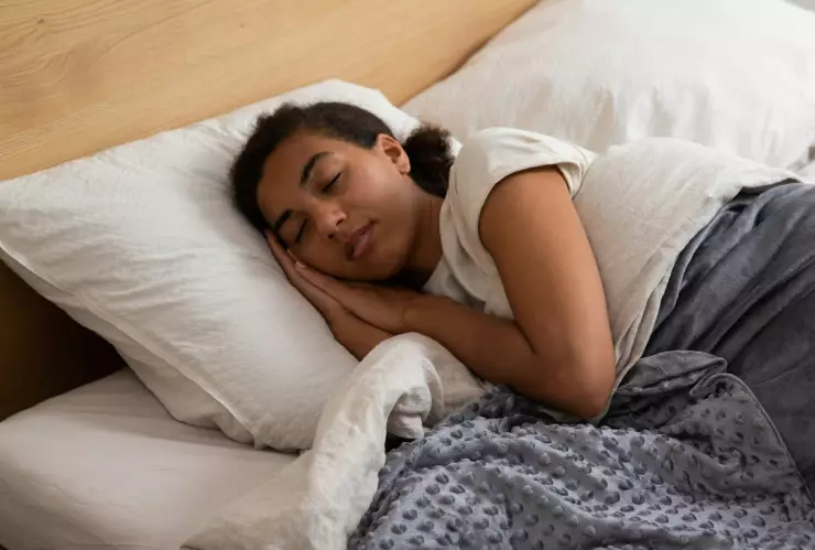 Mujer durmiendo en una cama.
